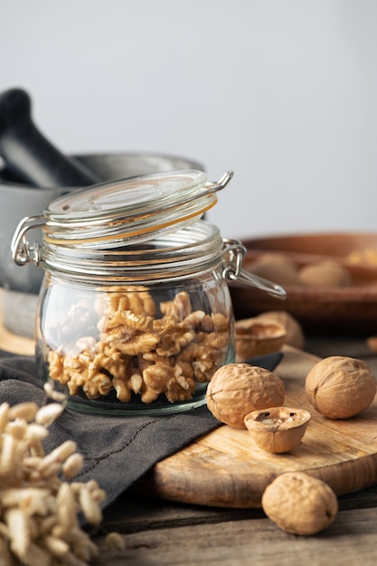 Nueces sabrosas con cáscaras de nuez divididas agrietadas en la mandíbula sobre una servilleta rústica y una mesa de madera. vertical