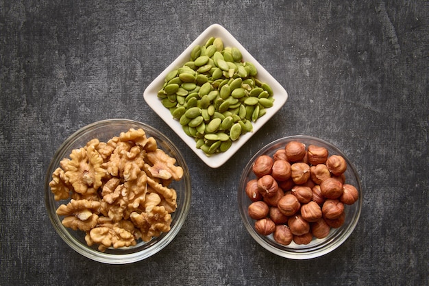 Nueces y semillas de calabaza de cerca en superficie gris