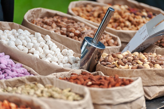 Nueces surtidas en cajas de papel para la venta en el mercado. Enfoque selectivo.