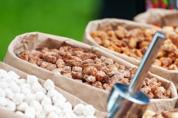 Nueces surtidas en cajas de papel para la venta en el mercado. Enfoque selectivo.