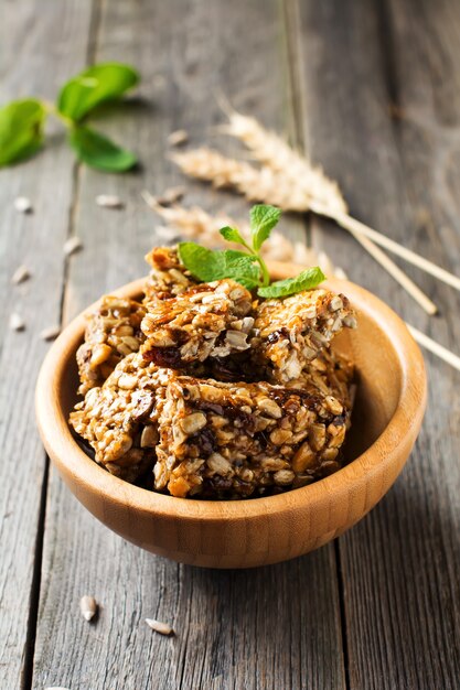 Nueces tostadas y semillas de girasol en caramelo y azúcar en un tazón de bambú sobre la mesa de madera vieja. Enfoque selectivo.