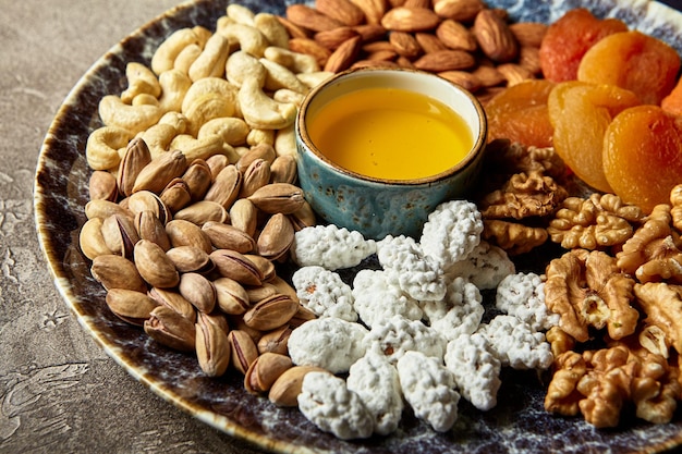 Nueces variadas y frutos secos al estilo oriental en un plato, albaricoques secos, anacardos, pistachos, almendras y nueces.