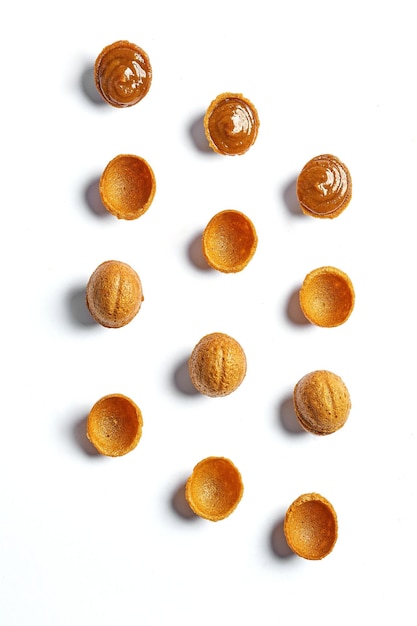 Nüsse mit Kondensmilch oder Karamell Muster auf weißem Hintergrund Minimalismus