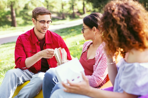 Nuestra determinación. Atractivo hombre concentrado sentado al aire libre con sus compañeros de trabajo y discutiendo su proyecto