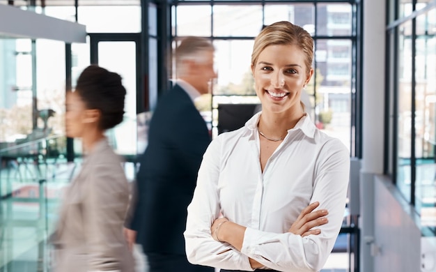 Nuestras oficinas son siempre un hervidero de actividad Retrato de una joven empresaria de pie en una oficina ocupada