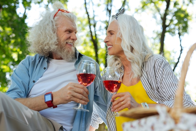 Nuestras vacaciones. Feliz pareja de ancianos mirando el uno al otro mientras celebra el aniversario