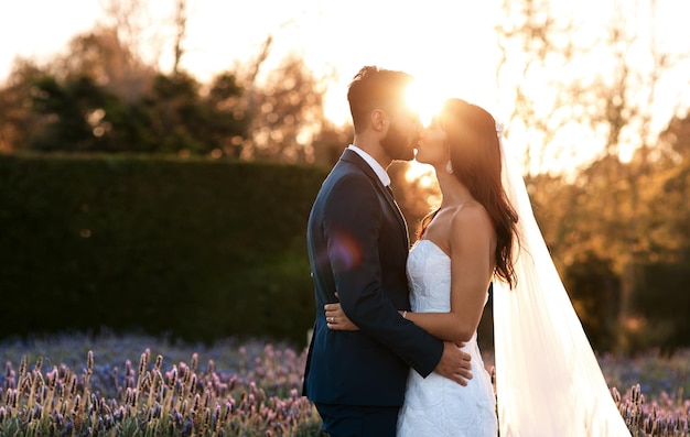 Nuestro amor seguirá creciendo Captura recortada de una joven pareja besándose el día de su boda