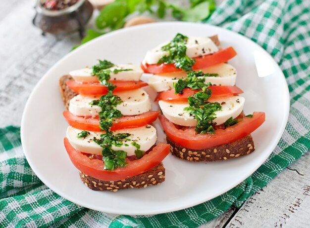 Nützliche diät-sandwiches mit mozzarella, tomaten und roggenbrot