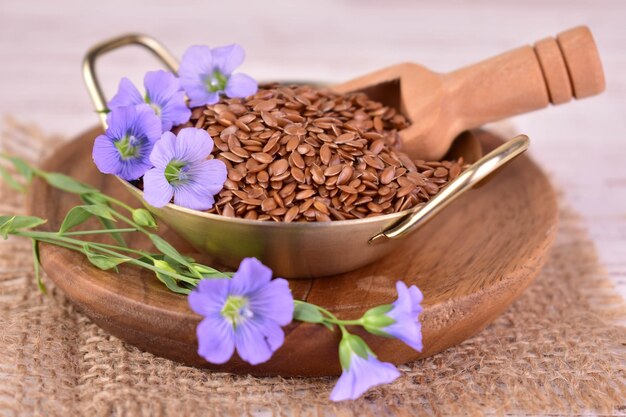 Foto nützliche leinsamen in einer metallschüssel mit leinsblumen nahaufnahme