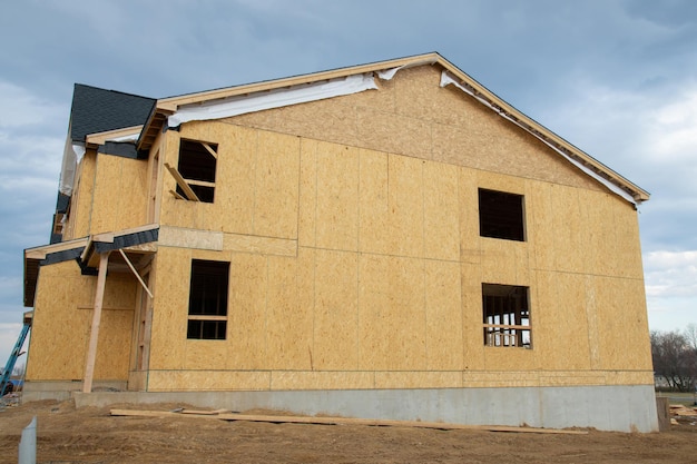 Nueva casa de madera contrachapada sin terminar contra el cielo azul