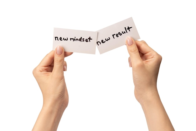 Nueva mentalidad nuevo resultado texto en una tarjeta en la mano de una mujer aislada sobre un fondo blanco