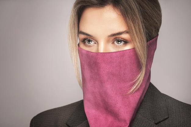 Nueva moda normal. Hermosa mujer vestida con elegante pañuelo de cuero en lugar de máscara de prevención.