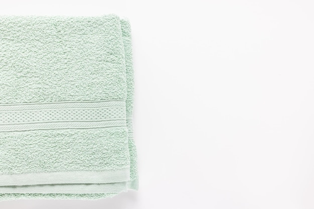 Nueva sábana de baño verde menta doblada o toallas en el espacio de copia de fondo blanco