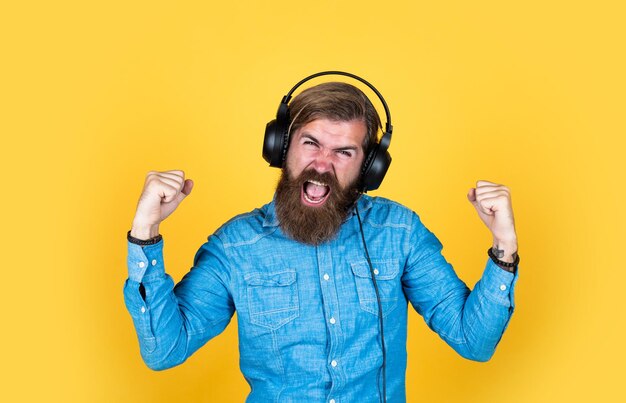 Nueva tecnología en la vida moderna el hombre feliz expresa emociones positivas el hombre escucha música en línea el concepto de aprendizaje del dj party el hombre en el pasatiempo de los auriculares solo diviértete