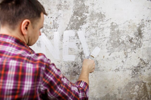 Foto la nueva vida comienza con la mejora del hogar el padre reparando la habitación y planeando el año en la pared