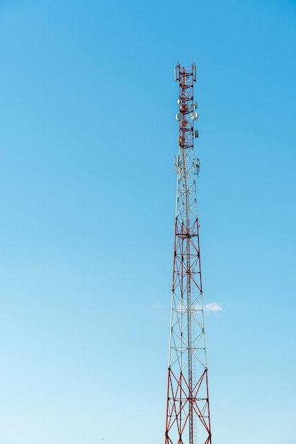 Las nuevas antenas GSM en una torre alta contra un cielo azul para transmitir una señal 5g son peligrosas para la salud La contaminación por radiación del medio ambiente a través de las torres celulares La amenaza de extinción