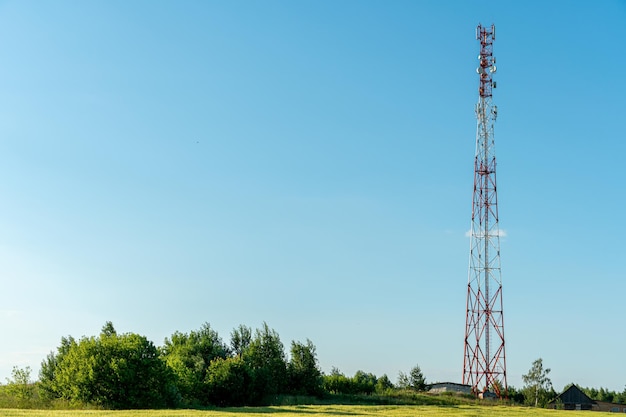 Las nuevas antenas GSM en una torre alta contra un cielo azul para transmitir una señal 5g son peligrosas para la salud La contaminación por radiación del medio ambiente a través de las torres celulares La amenaza de extinción