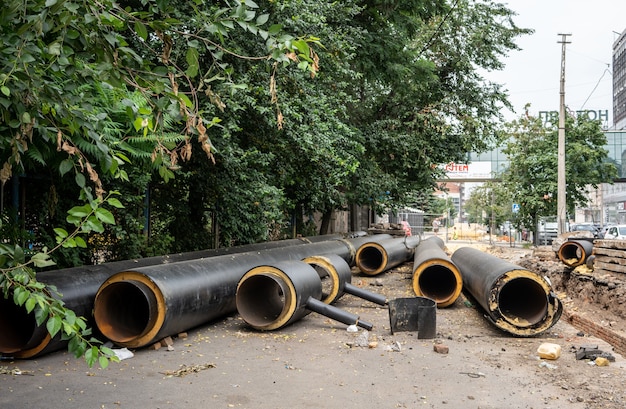 Nuevas tuberías de agua negras aisladas al aire libre en un día de verano cerca de árboles verdes