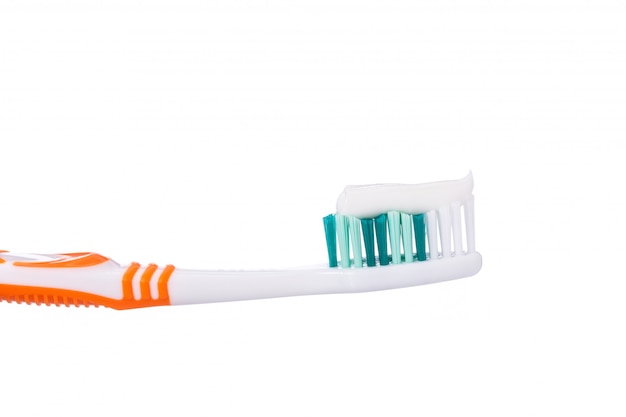 Nuevo cepillo de dientes naranja con pasta de dientes.