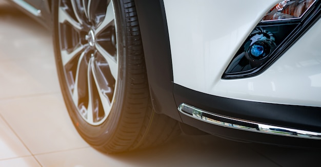 Nuevo coche blanco de lujo estacionado en la moderna sala de exposición para la venta. Oficina de concesionario de automóviles. Tienda minorista de automóviles. Tecnología de automóvil eléctrico o híbrido. Industria automotriz.