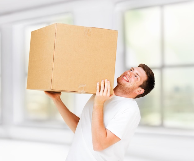 Nuevo concepto de entrega a domicilio y posterior: hombre que lleva una caja pesada de cartón