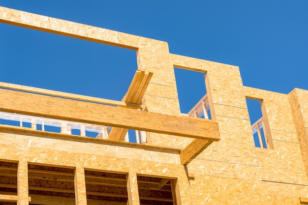 Nuevo edificio residencial en construcción sobre fondo de cielo azul Marco de madera de baja altura del edificio