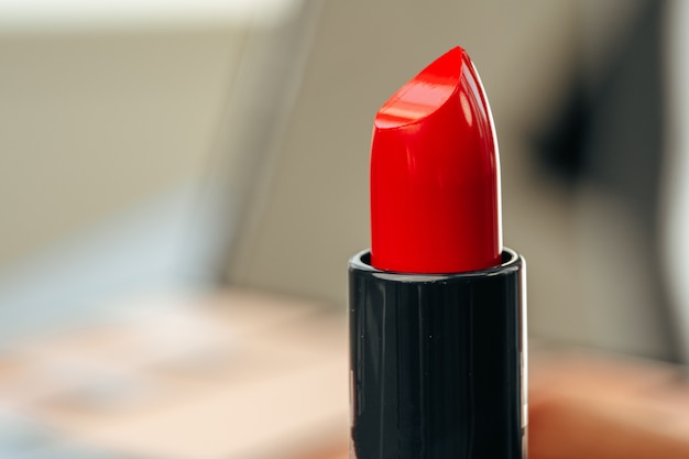 Nuevo lápiz labial rojo en el tocador de cerca