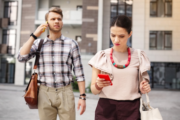 Nuevo mensaje. Bonita mujer atractiva mirando la pantalla de su teléfono inteligente mientras revisa nuevos mensajes