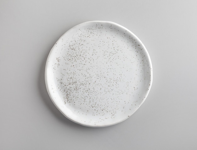 Nuevo plato blanco vacío en la mesa de la cocina gris, vista superior