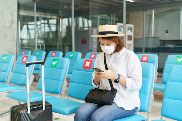 Nuevo turista normal con mascarilla viaja en el aeropuerto