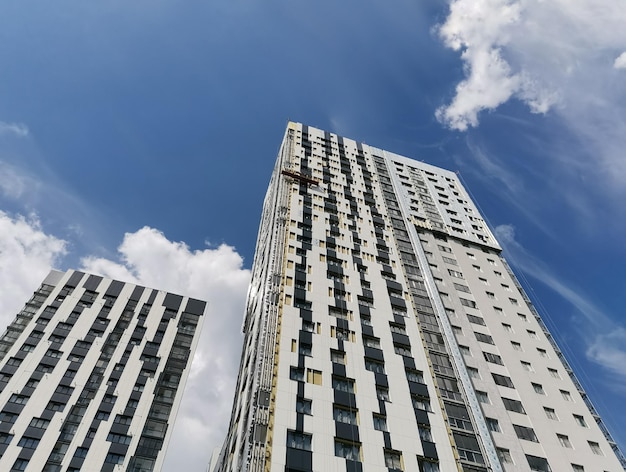 Nuevos edificios residenciales de varios pisos en blanco y negro sobre cielo azul con fondo de nubes blancas