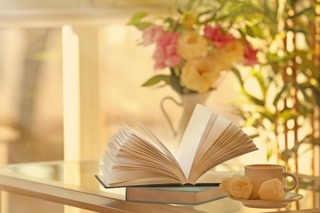 Nuevos libros en la mesa con taza de café.