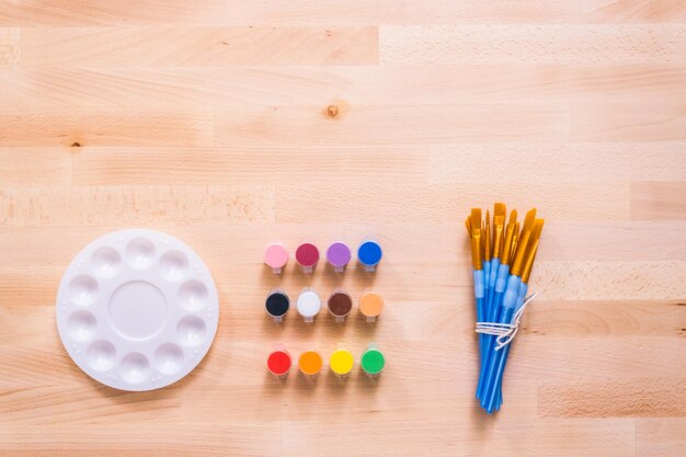 Nuevos suministros de pintura en una mesa de madera.