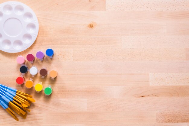 Nuevos suministros de pintura en una mesa de madera.