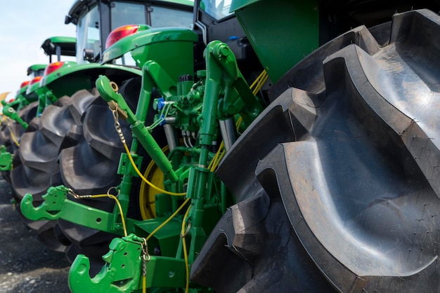 Nuevos tractores agrícolas en el campo en una fila, enfoque selectivo, vista lateral - Fotografía de stock