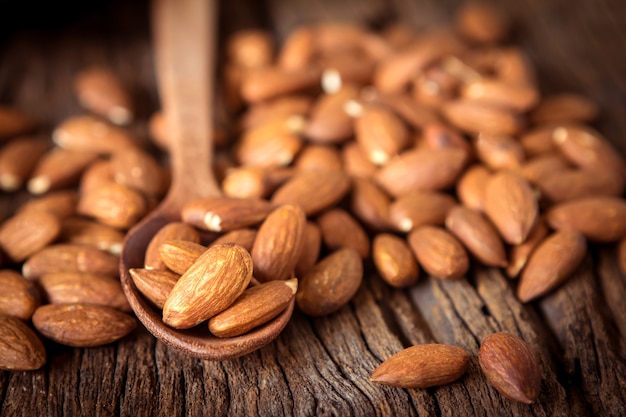 Nuez de almendras peladas en cuchara sobre fondo de madera