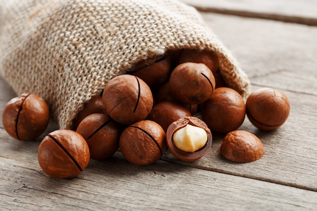 Nuez de macadamia en una mesa de madera en una bolsa