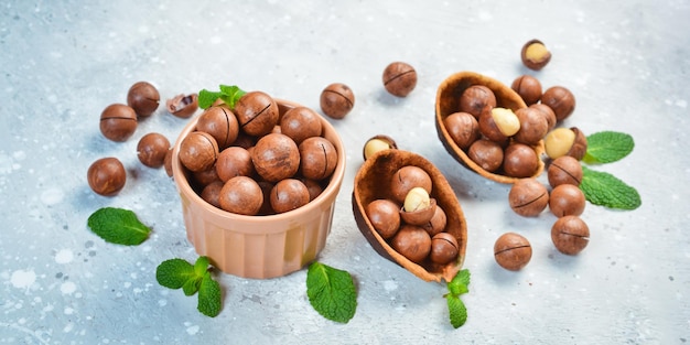 Nuez de macadamia Nueces de macadamia en una cáscara en un bol Sobre un fondo de piedra Las nueces de macadamia son ricas en diversos oligoelementos y vitaminas