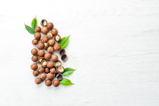 Nuez de macadamia en un recipiente sobre fondo blanco de madera