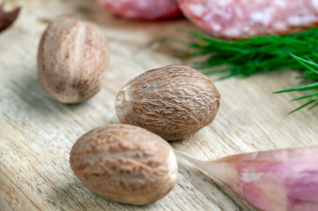 Una nuez moscada entera sobre una tabla de madera una nuez moscada entera que se usa para cocinar cuando se preparan platos de carne