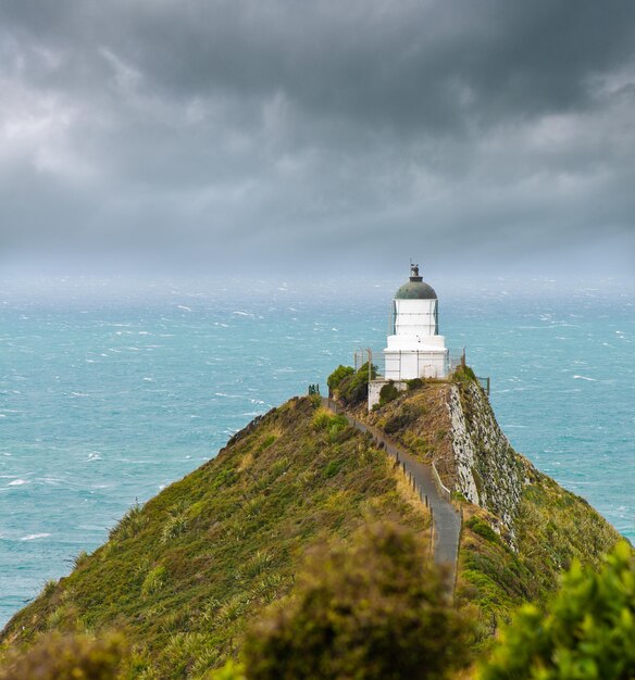 Foto nugget point light house e nuvens escuras no céu