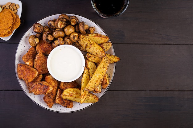 Nuggets de frango com ketchup, batata frita, cogumelos assados e cola