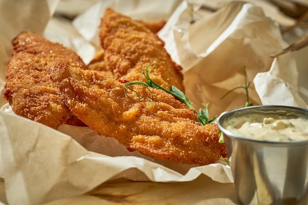 Nuggets de frango com molho em uma toalha de mesa branca luz dura foco seletivo closeup