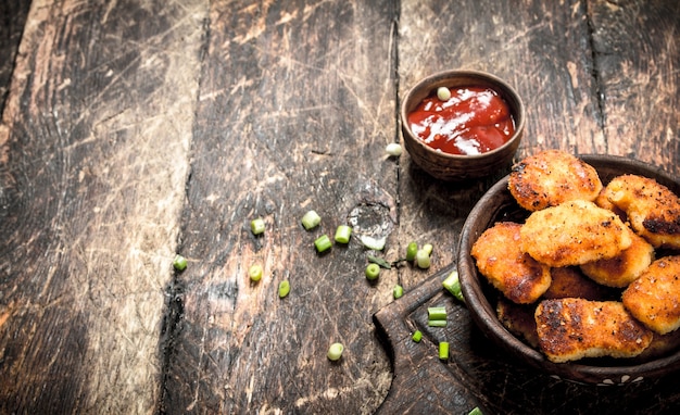 Nuggets de frango em uma tigela com molho de tomate.