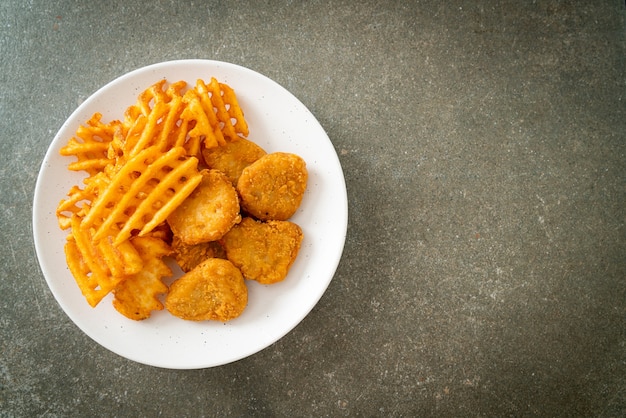 nuggets de frango frito com batatas fritas no prato