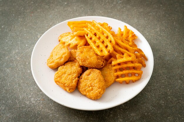 nuggets de frango frito com batatas fritas no prato