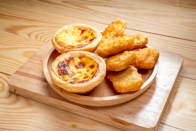 Nuggets de frango frito com torta de ovo em fundo de madeira