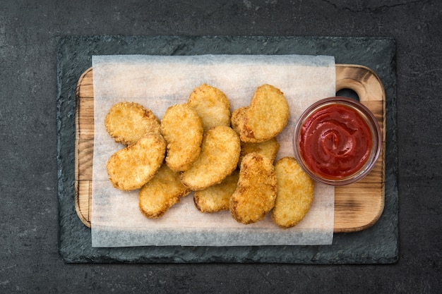 Nuggets de frango frito na vista superior de ardósia preta