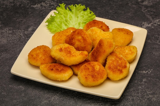 Nuggets de frango fritos servidos com folhas de salada