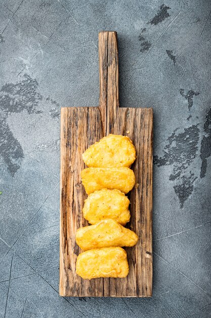 Nuggets de peito de frango frito na mesa cinza, vista superior.